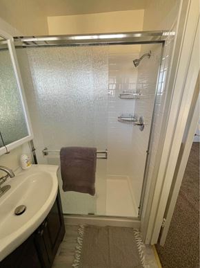 Hayward apartment for rent - A bathroom with a white sink and a glass shower door.