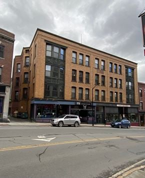 Brattleboro apartment for rent - A street view of a building with cars parked in front.