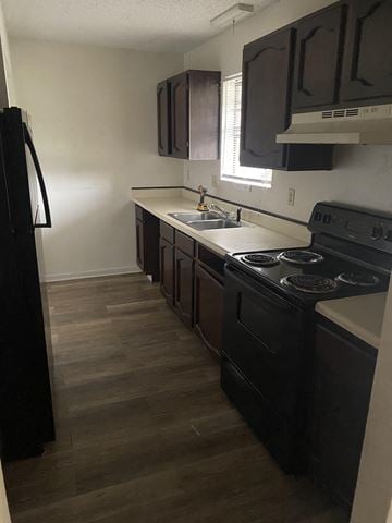 Lafayette apartment for rent - A kitchen with black appliances and brown cabinets.