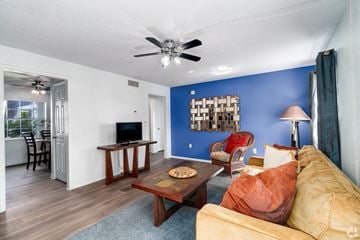 Winter Park apartment for rent - A living room with a yellow couch and a wooden coffee table.