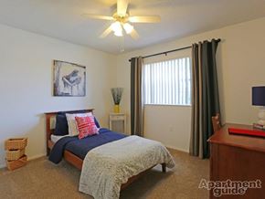 Winter Park apartment for rent - A bedroom with a bed, a ceiling fan, and a painting of a piano.