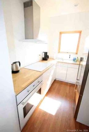 New Haven apartment for rent - A kitchen with white appliances and wooden floors.