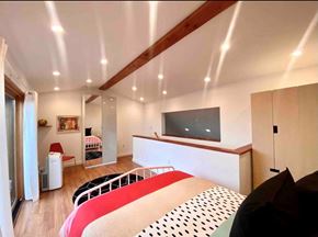 New Haven apartment for rent - A bedroom with a red and white bed and a television on the wall.