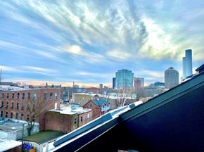 New Haven apartment for rent - A cityscape with a mix of modern and older buildings under a partly cloudy sky.