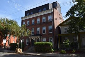 New Haven apartment for rent - A red brick building with a yellow house in front of it.