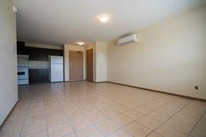 Brandon apartment for rent - an empty kitchen and living room with tile flooring and white appliances