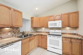North Port house for rent - a kitchen with white appliances and wooden cabinets