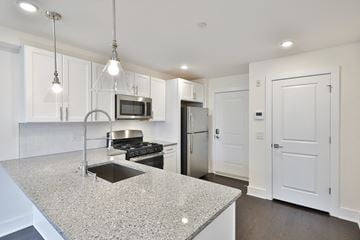 Philadelphia apartment for rent - a kitchen with white cabinets and a granite counter top