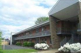 Warwick apartment for rent - a large brick building with white flowers in front of it