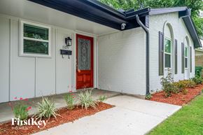 Garland house for rent - A white house with a red door and a black mailbox.