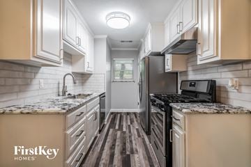 Garland house for rent - A kitchen with a black refrigerator and a black microwave.