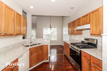 Clarkston house for rent - a kitchen with wooden cabinets and granite counter tops and a stove top oven