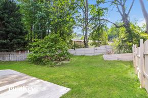 Clarkston house for rent - a backyard with a fence and grass and trees