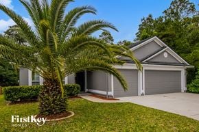 Jacksonville house for rent - A palm tree stands in front of a house with a garage.