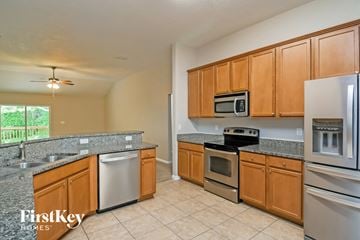 Jacksonville house for rent - A kitchen with wooden cabinets and stainless steel appliances.