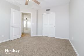 Waddell house for rent - a bedroom with two closets and a carpeted floor and a ceiling fan