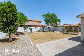 Waddell house for rent - a backyard with a grass lawn and a white fence