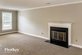 Greensboro house for rent - a living room with a fireplace and a carpeted floor