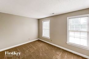 Greensboro house for rent - a bedroom with carpet and two windows