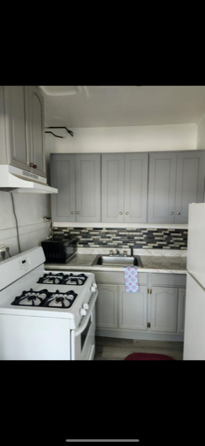 Los Angeles apartment for rent - A kitchen with a white stove and cabinets.