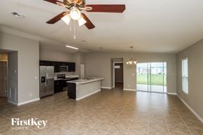 Palm Bay house for rent - A spacious kitchen and living room with a ceiling fan and tiled flooring.