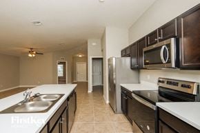 Palm Bay house for rent - A kitchen with a sink, stove, and refrigerator.
