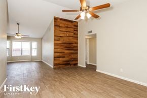 Glendale house for rent - A room with a ceiling fan and wooden stairs.