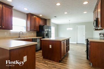 Indianapolis house for rent - an open kitchen with wooden cabinets and white counter tops