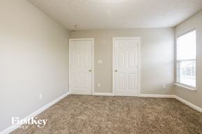 Indianapolis house for rent - a carpeted living room with two doors and a window