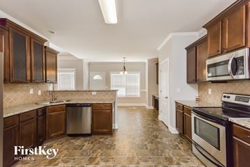 Mcdonough house for rent - a kitchen with wooden cabinets and stainless steel appliances