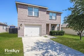 San Antonio house for rent - A brick house with a garage door and a tree in front.