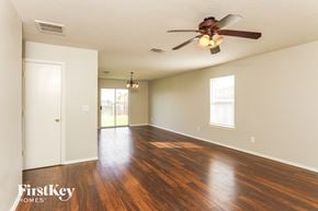 San Antonio house for rent - A room with a ceiling fan and wooden floors.