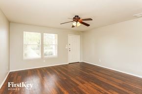 San Antonio house for rent - A room with a ceiling fan and wooden flooring.