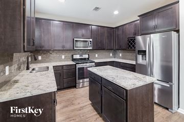 Summerville house for rent - a kitchen with stainless steel appliances and marble counter tops