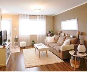 Saskatoon apartment for rent - A living room with a brown couch, a white coffee table, and a white rug.