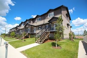 Saskatoon apartment for rent - A row of houses with a tree in the front yard.