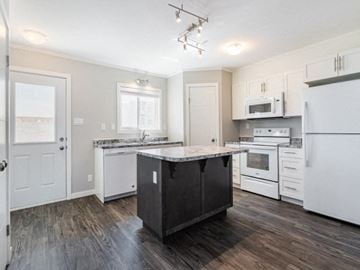 Saskatoon apartment for rent - a kitchen with white appliances and a counter top