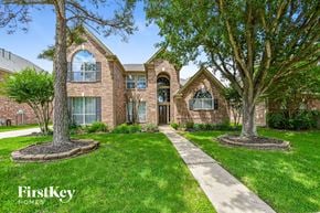 Houston house for rent - front view of a brick house with trees and grass