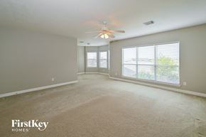 Houston house for rent - an empty living room with a ceiling fan and a large window