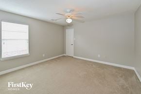 Houston house for rent - a bedroom with a ceiling fan and a window