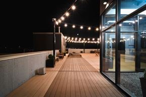 Edmonton apartment for rent - a roof terrace at night with string lights and wooden decking
