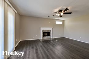 Collierville house for rent - A spacious room with a fireplace and a ceiling fan.