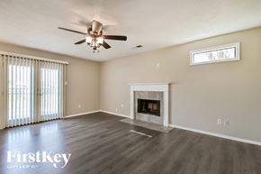 Collierville house for rent - A spacious living room with a fireplace and a ceiling fan.