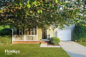 Huntersville house for rent - A house with a white garage door is shown with a tree in front.