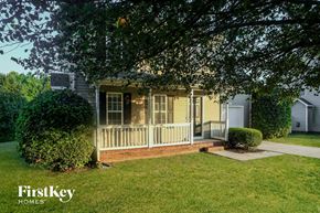 Huntersville house for rent - A house with a porch and a tree in front of it.