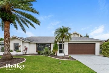 Cape Coral house for rent - a white house with palm trees in front of it