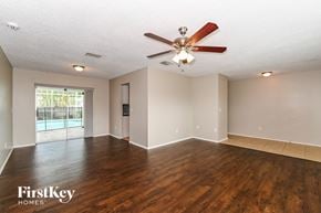 Cape Coral house for rent - an empty living room with wood floors and a ceiling fan