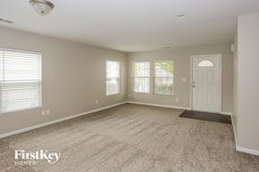 Charlotte house for rent - A spacious room with a carpeted floor and a door on the right side.