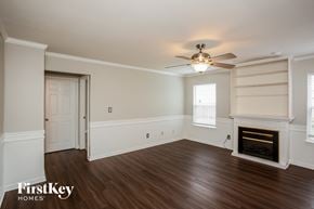 Indianapolis house for rent - A room with a fireplace and a ceiling fan.