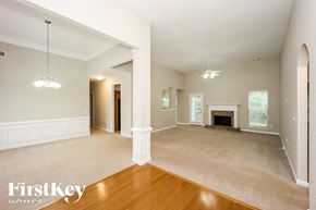 Dallas house for rent - A spacious living room with a fireplace and a chandelier.